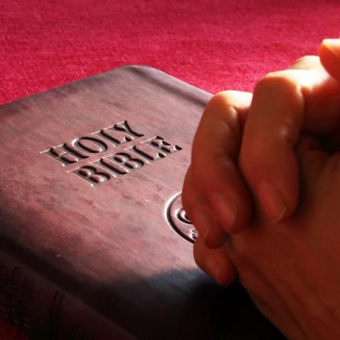 Person hands on holy bible 